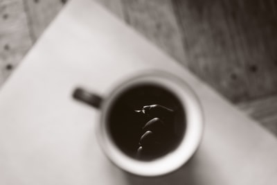 白色和黑色陶瓷杯米色木桌上
